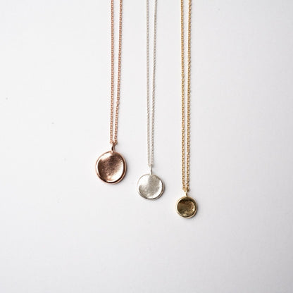 A photo of three pendants in three sizes and three metal choices.