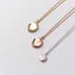 Three impression pendants on chains, in yellow gold, rose gold and silver, displayed on a clean white background. 